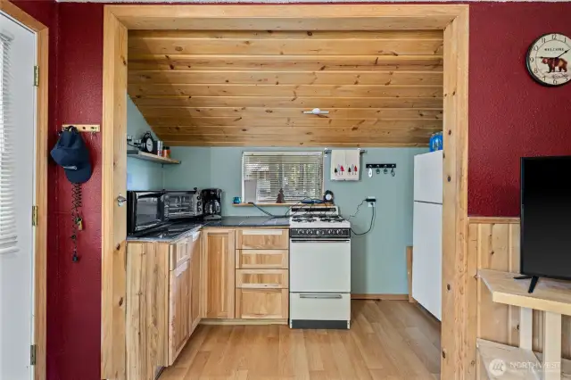 Main Cabin Kitchen has a propane stove, refrigerator, coffee maker, air fryer, and microwave - all included.