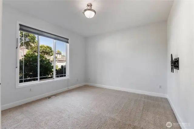 Versatile main floor space—pictured here without furniture to showcase its full potential. Whether you envision a home office, playroom, fitness studio, or creative retreat, this room adapts to your needs.