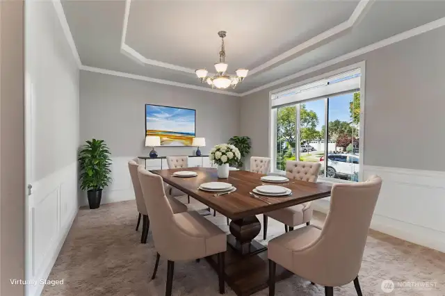 wainscoting and crisp white trim, enhanced by a large window that fills the space with natural light. A coved ceiling adds architectural charm, while convenient access to the butler’s pantry and kitchen makes entertaining a breeze.
