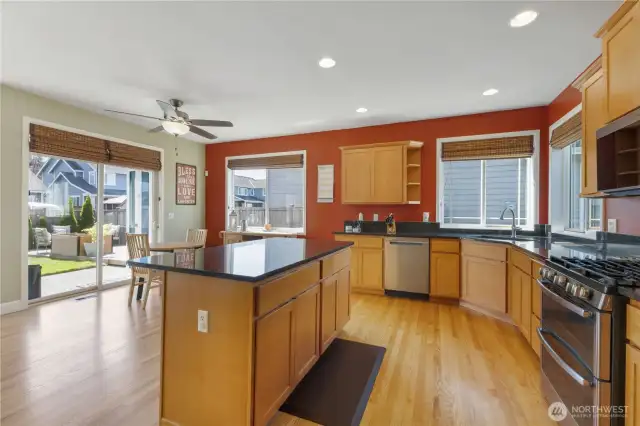This beautifully designed kitchen features granite countertops and matching backsplash, pantry, and an abundance of cabinet and counter space. Enjoy cooking with stainless steel appliances, including a gas range and brand-new microwave. The center island with breakfast bar is perfect for casual meals, and a separate eating area offers even more space to gather.