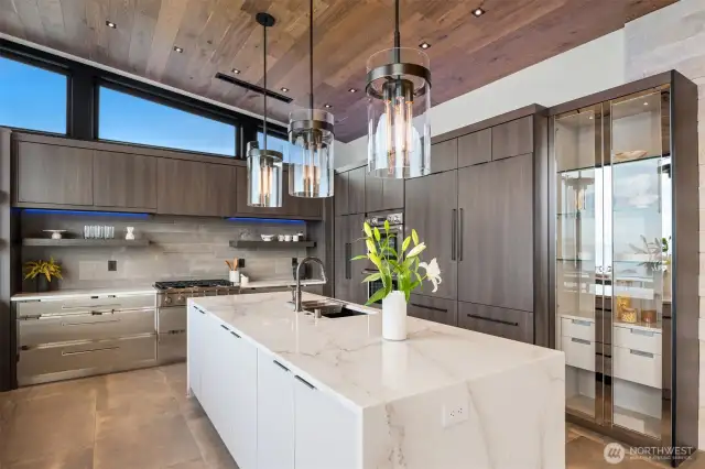 The custom stainless steel cabinetry from Italy features a one of a kind mirrored glass display cabinet for your fine collectibles.