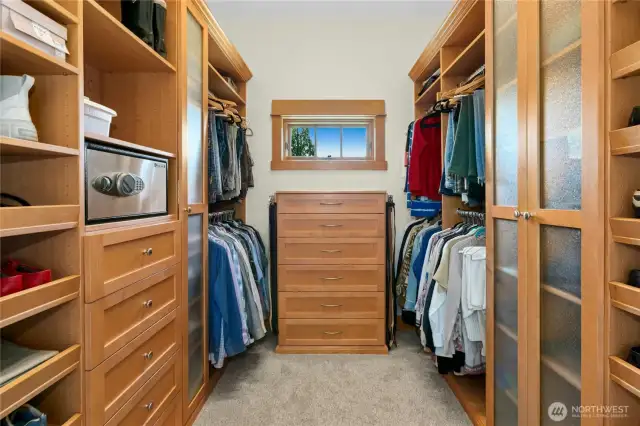 Primary suite walk-in closet with built in organizers and a window for natural light so you do not mix your navy-blue shoes with your black shoes!