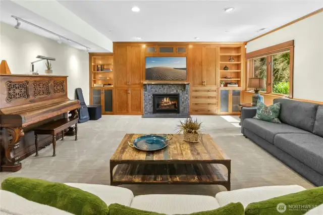 Lower-Level Recreational Room with gas fireplace, built-in ceiling speakers, back-lit bookcases and access to an additional heated patio with Mt. Rainier views.