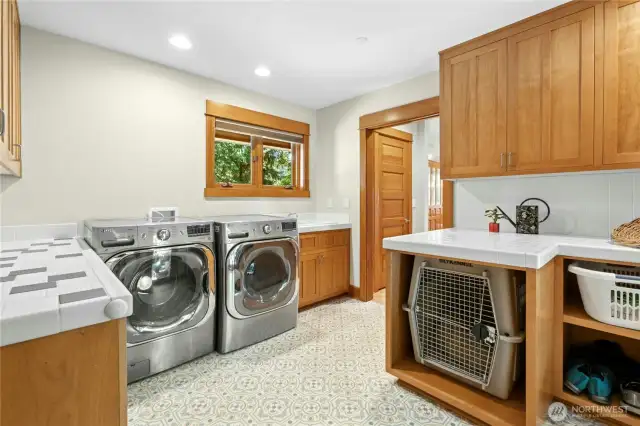 Laundry area boasts a High Capacity Washer and Dryer, Utility sink, lots of storage and a Built-in Nook for a large dog crate.