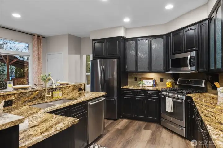 Kitchen with SS appliances, gas cooking, and granite counters.