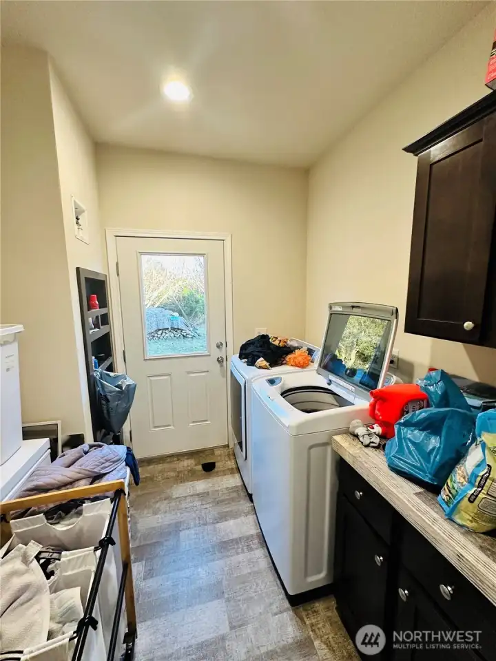 The utility room has extra counter space & storage area, hot water heater has a storage area cabinet for extra storage.