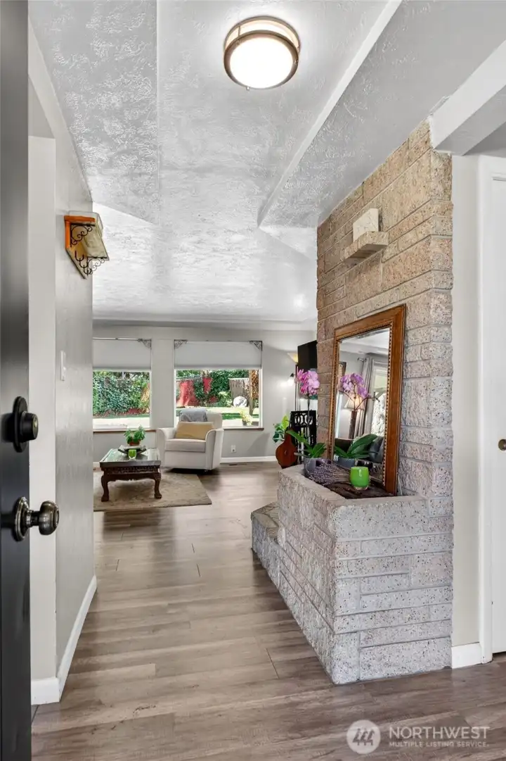 Enter into the light & bright home, seeing the start of the full wall brick fireplace that steals the show in the living room.