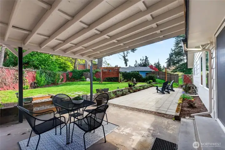 From the Dining area, step through the slider to the partially covered patio where you can hang out all year long.  or head up the stairs to the upper terraced yard to play with the kids or dogs.
