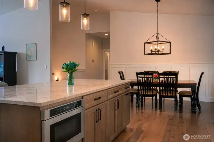 Modern dining and kitchen space with elegant finishes and warm lighting. Modern dining and kitchen space with elegant finishes and warm lighting.