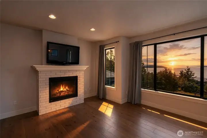 Cozy fireside living with stunning sunset and water views. Cozy fireside living with stunning sunset and water views.