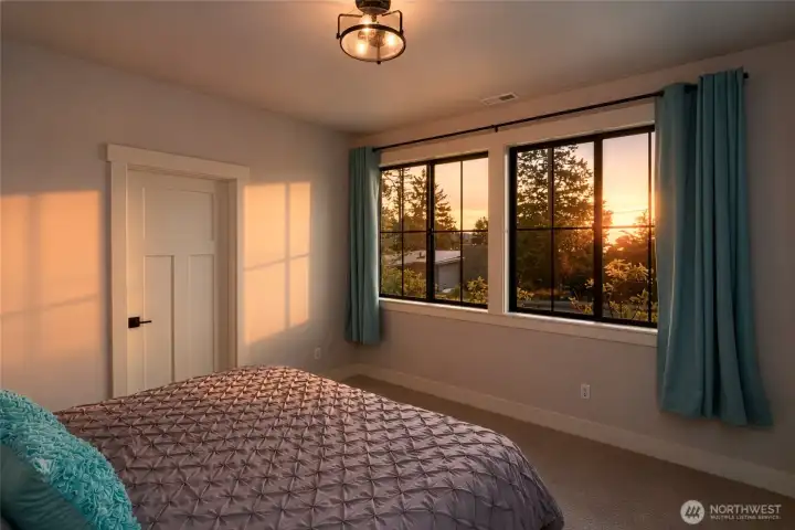 Bright bedroom with sunset views and warm natural evening light. Bright bedroom with sunset views and warm natural evening light.