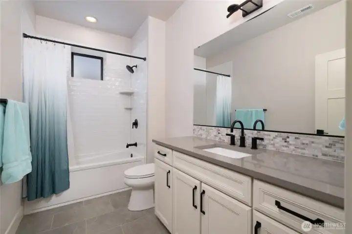 Stylish full bath with modern finishes and sleek black accents. Stylish full bath with modern finishes and sleek black accents.