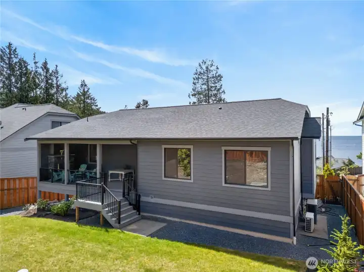 Covered patio and spacious backyard with peekaboo water views. Covered patio and spacious backyard with peekaboo water views.