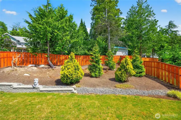 Beautifully landscaped backyard with mature trees and privacy fencing. Beautifully landscaped backyard with mature trees and privacy fencing.
