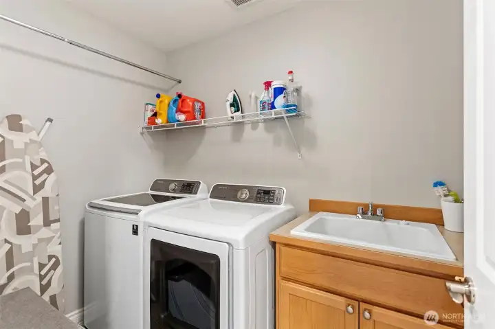 Laundry with wash basin. Full sized washer dryer stay.