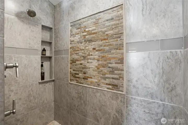 Large walk-in custom tiled shower in the primary suite. Large walk-in custom tiled shower in the primary suite.