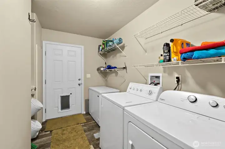 Large full sized laundry room with door to backyard.