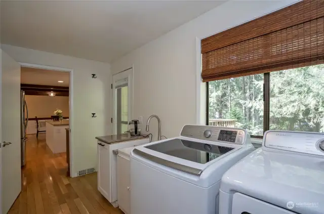 The main floor laundry space features a separate entrance to the back deck, utility sink, countertops for folding, and plenty of cabinet space. This is also how you access the garage.