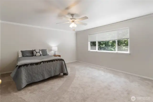 The spacious primary suite offers serene views of the lush backyard, creating a private retreat you'll love coming home to.
