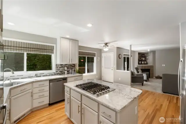 The stunning, updated kitchen overlooks the backyard and features sleek stainless steel appliances, including a double oven and gas cooktop. Designed with an open layout, it seamlessly connects to the family room—perfect for entertaining and staying connected with guests.