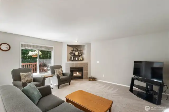Natural light fills the family room just off the kitchen, creating a warm and welcoming space. Cozy up by the fireplace and unwind with a good book.