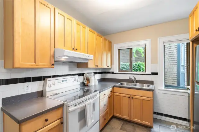 The kitchen boasts tiled walls, two windows, maple cabinets & space for culinarily creativity.