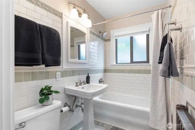 The bath features subway tiles, original ceramic floor, pedestal sink & a nice soaking tub.