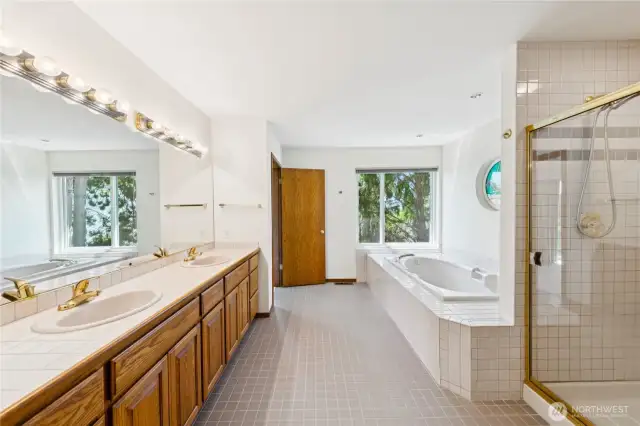 Large ensuite with soaker tub, double vanity, and enclosed water closet.