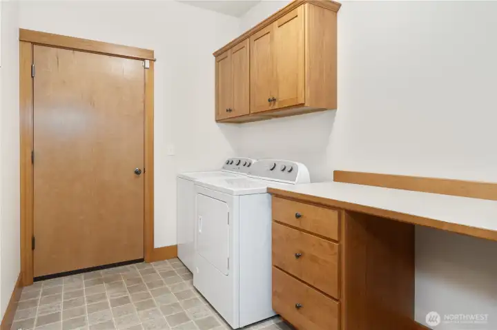 Laundry with folding station leads to garage.