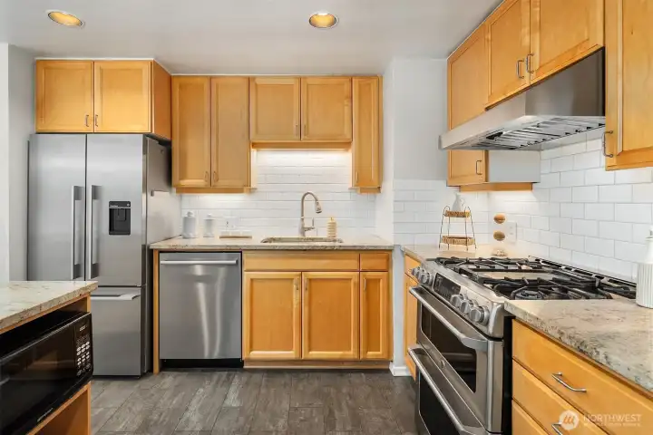 Updated kitchen with gas range, granite counters, and subway tile backsplash Updated kitchen with gas range, granite counters, and subway tile backsplash