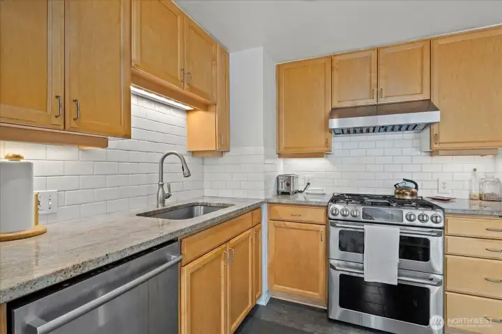 Kitchen with stainless steel appliances, tile backsplash and gas range