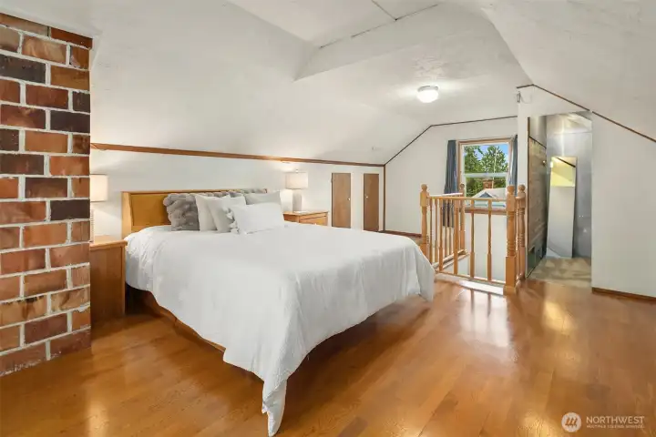 Primary suite showcasing original brick chimney detail and Cape Cod roofline character Primary suite showcasing original brick chimney detail and Cape Cod roofline character