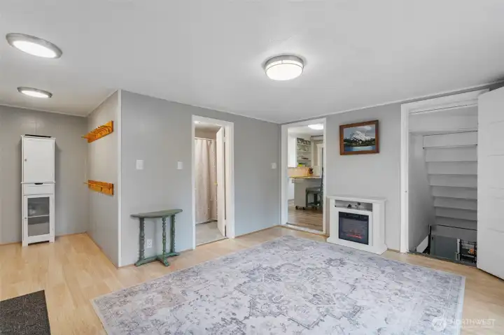 From opposite corner of the family room, you can see the mudroom area at left, center door to bath, then to kitchen and down to basement level.