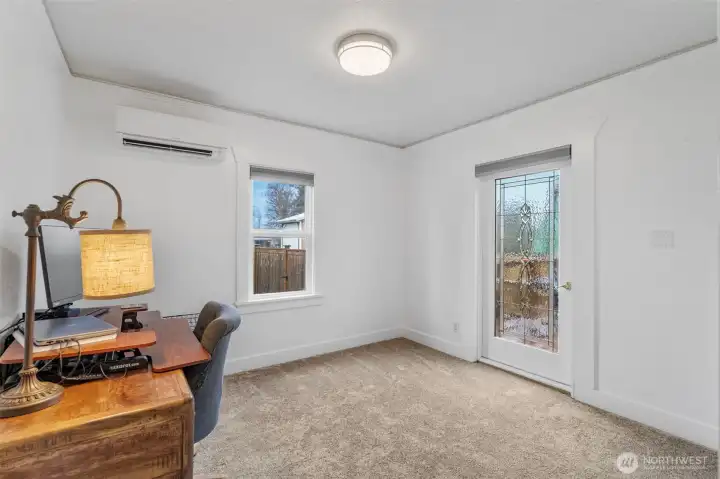 One of the bedrooms of the home is here on the main level. The leaded glass door leads to the deck.