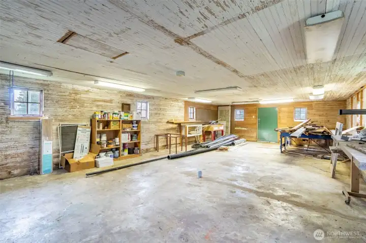 This is the opposite side of the shop area. Note that the wood pile at the end and the radial arm saw continue to stay with the home ... it was all here when the seller's purchased in 2022.