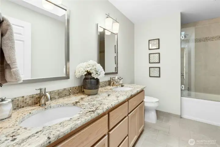 The upstairs hall bath has also been renovated. It has a large tub/shower and double sinks, and extra storage too! Also not seen in this picture - a lovely skylight!