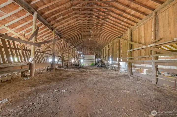 Spacious barn interior with exposed beams, open span construction, and ample room for storage, equipment, or agricultural use. Spacious barn interior with exposed beams, open span construction, and ample room for storage, equipment, or agricultural use.