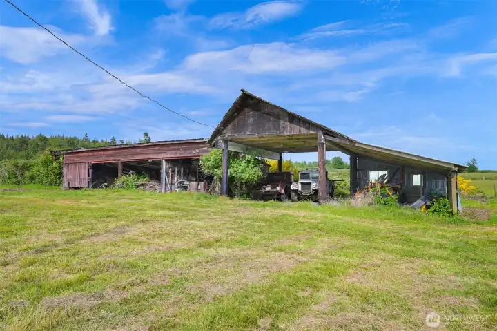 Traditional barn with original character and expansive footprint set against open acreage and nearby water views. Traditional barn with original character and expansive footprint set against open acreage and nearby water views.