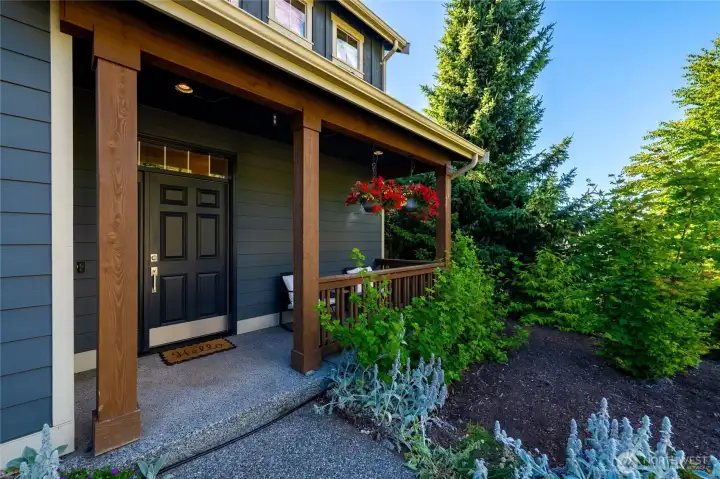 The covered front porch overlooks the beautifully landscaped front yard.