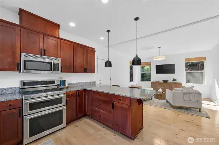 The kitchen features stainless appliances and an eating bar.