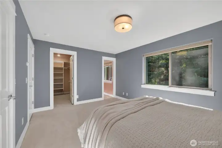 A view of the walk in closet and door to the primary bathroom.