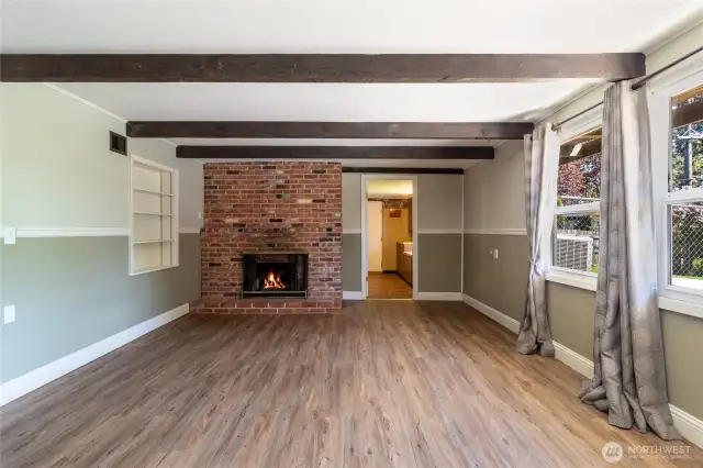 LL family room with wood burning fireplace and windows to backyard