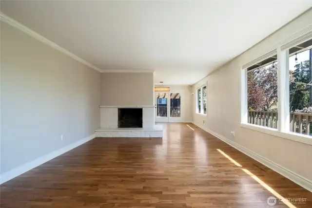 Living room with wood burning fireplace and large picture windows looking out to Blue Mountain views.