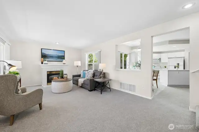 The spacious living room is open to the kitchen and has two large, sunny windows and a gas fireplace. All new carpeting throughout the home!