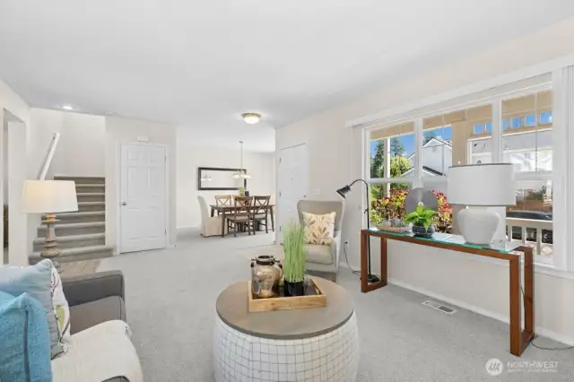 Another look at the living room and its connection to the stairs, entry, and dining room. That window overlooks the front porch.
