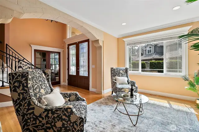 A stunning arched stone entry frames the living room area by creating a dramatic yet cozy space perfect for large gatherings or quiet evenings.  The double doors leas to the main floor study.
