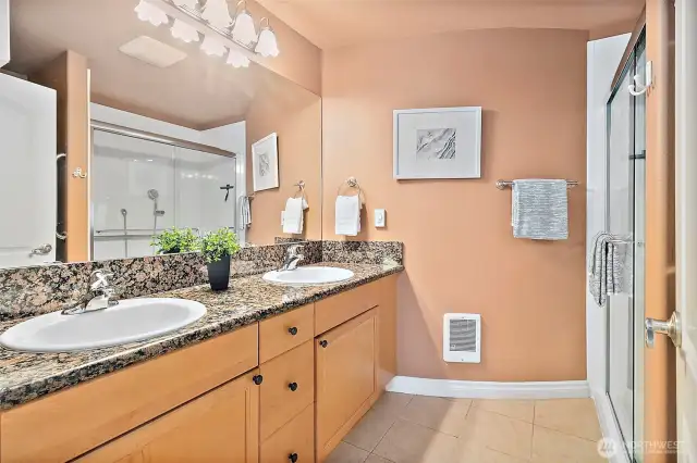 Lovely 3/4 bath on the lower level featuring dual sinks, granite countertops and a walk-in shower. This bathroom is a stylish and functional space for guests or extended stays.