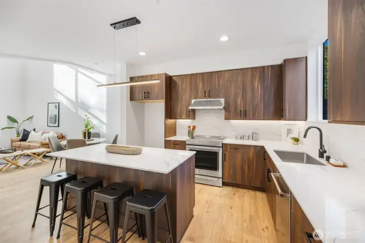 Seated island also offers more storage, stainless appliances, quartz counter tops. Photo is of model home of same floorplan. Color schemes of finishes may vary.