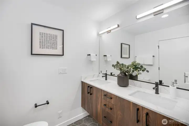 Primary bathroom offers dual sink vanity, ample countertop and storage space! Photo is of model home of same floorplan. Color schemes of finishes may vary.