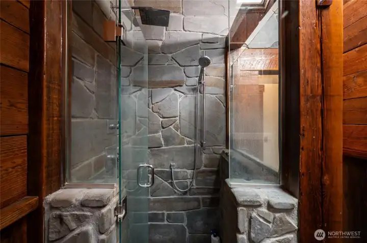 A custom stone shower in the primary suite bathroom